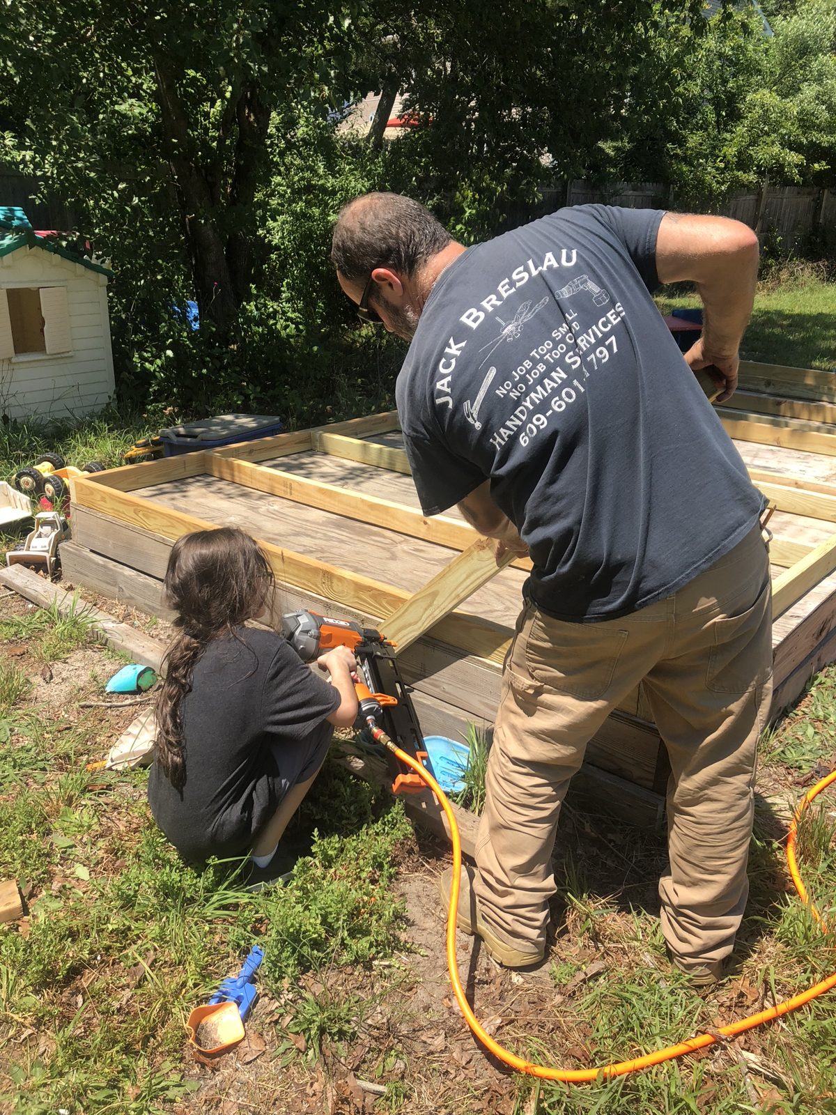 A young helper working on a deck frame